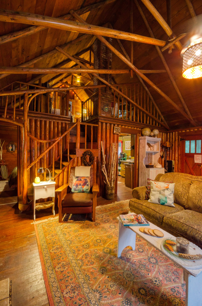 Vaulted ceilings in this log beamed ceiling with half log stairs to the loft